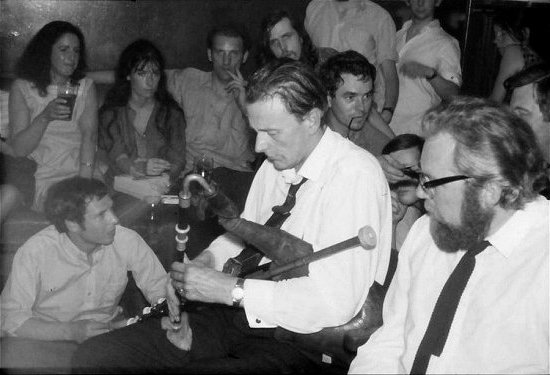 Seamus Ennis. Stitting around him are Ken Hamer, Jenny Morley, Tony Hall, Johnny Moynihan, Tony Engle, Chris Morley, Tony Foxworthy, Reg Hall ... 